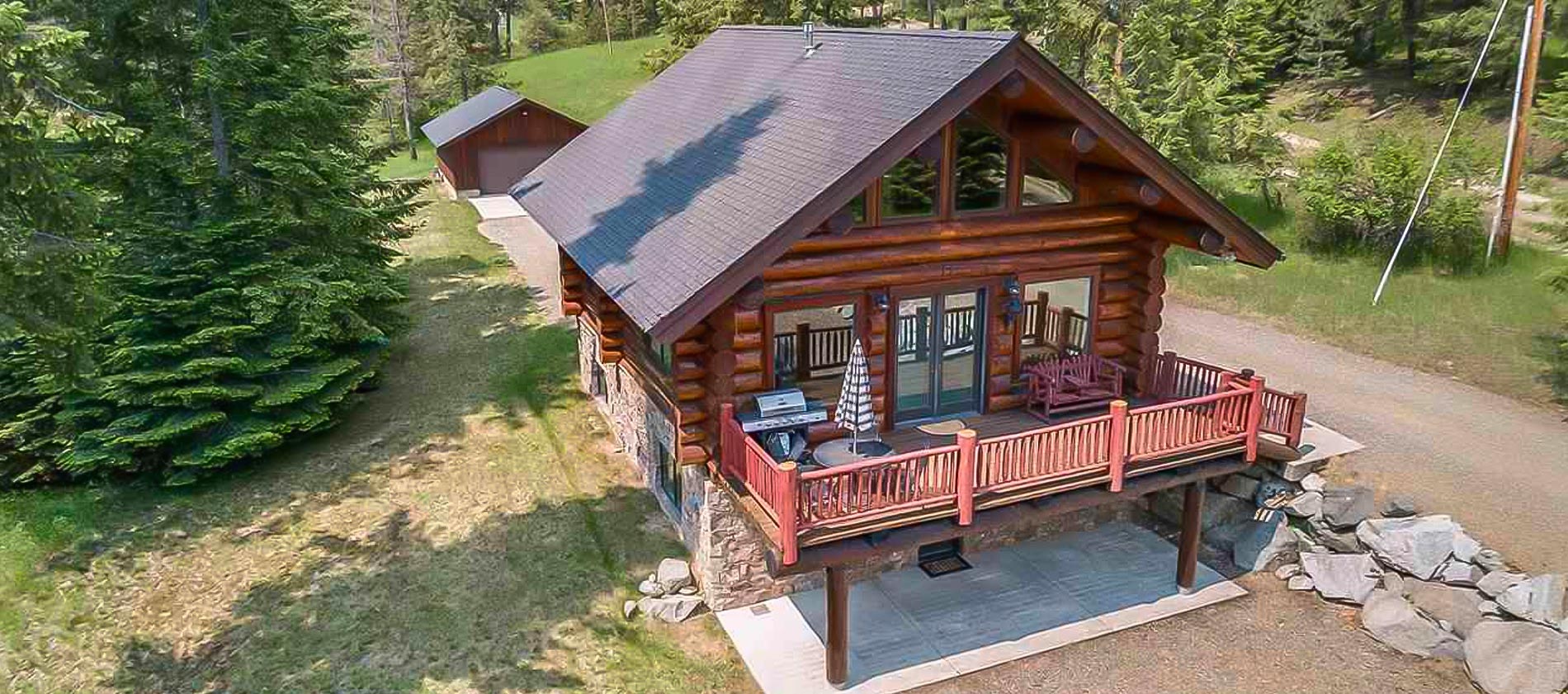 Beautiful custom log home with dry stack native rock, resting by a cedar adorned stream